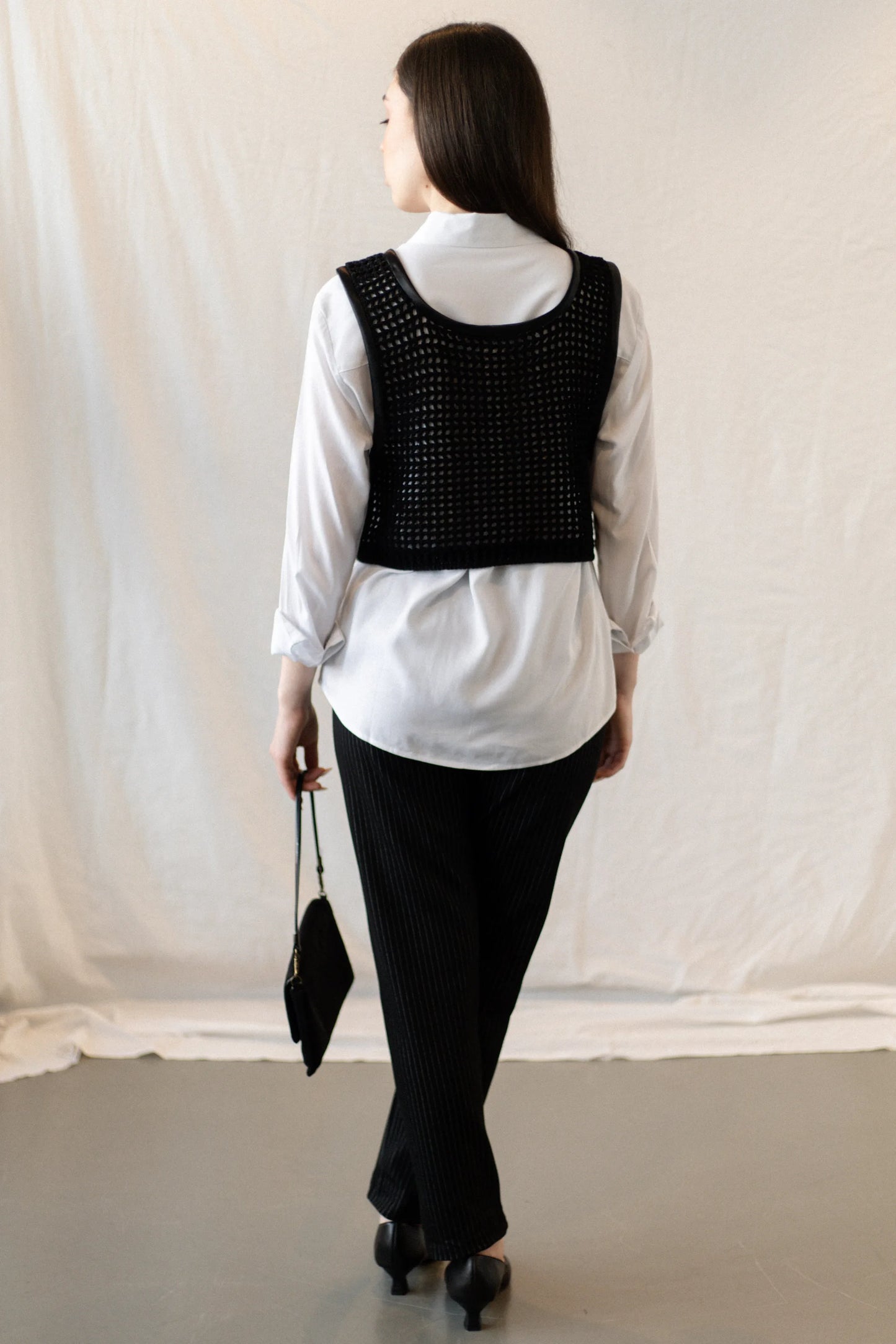 Vista espalda cuerpo entero del Chaleco Regaliz en negro tejido a crochet con algodón mercerizado
