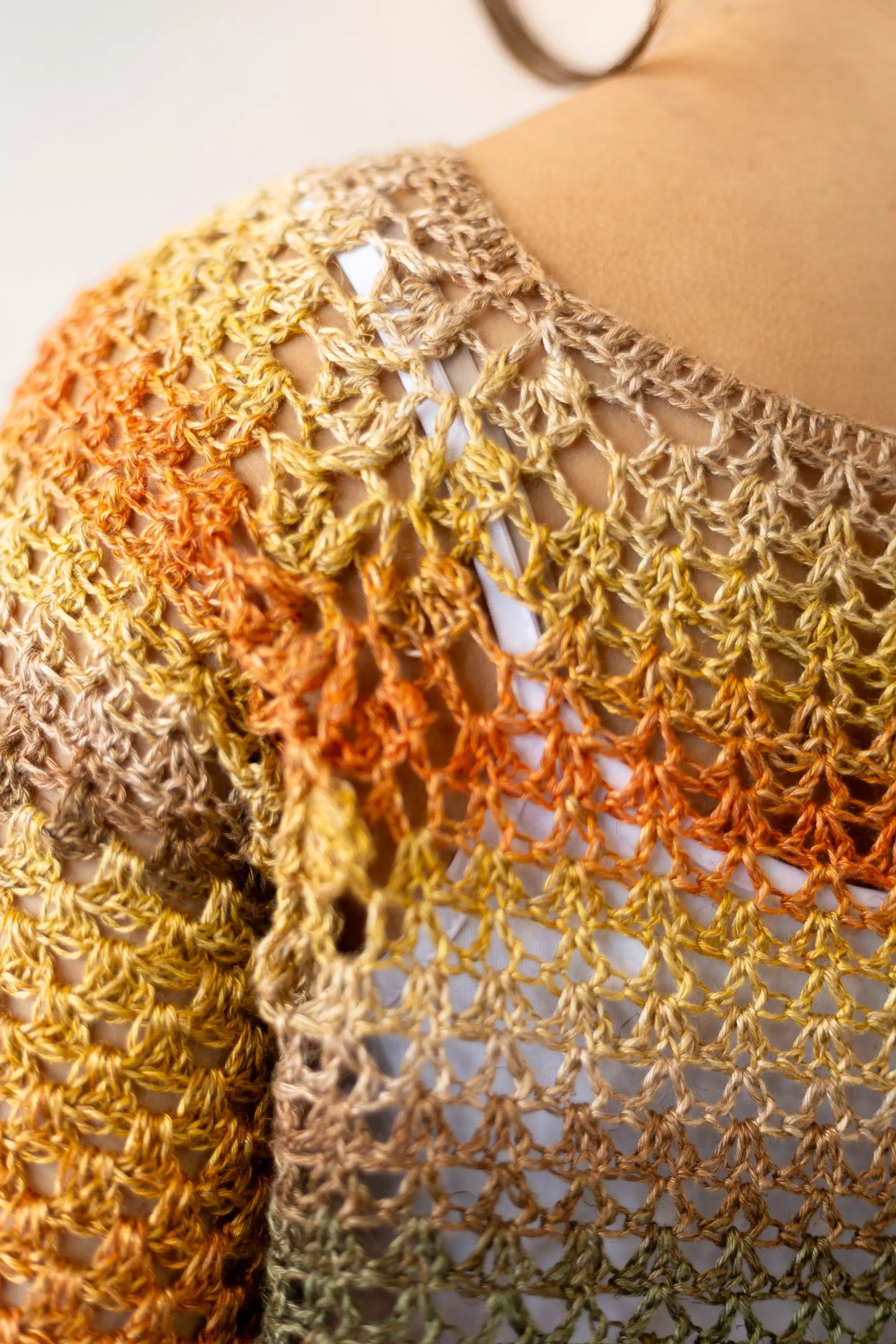 Vista detalle punto espalda del Jersey Belleza tejido a crochet en tonos naranjas y verdes