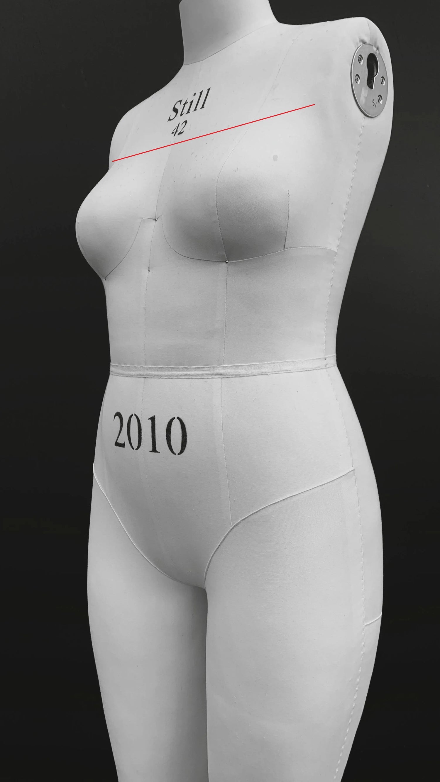 Maniquí indicando con una línea recta roja cómo medir el ancho de pecho de una sisa a otra.