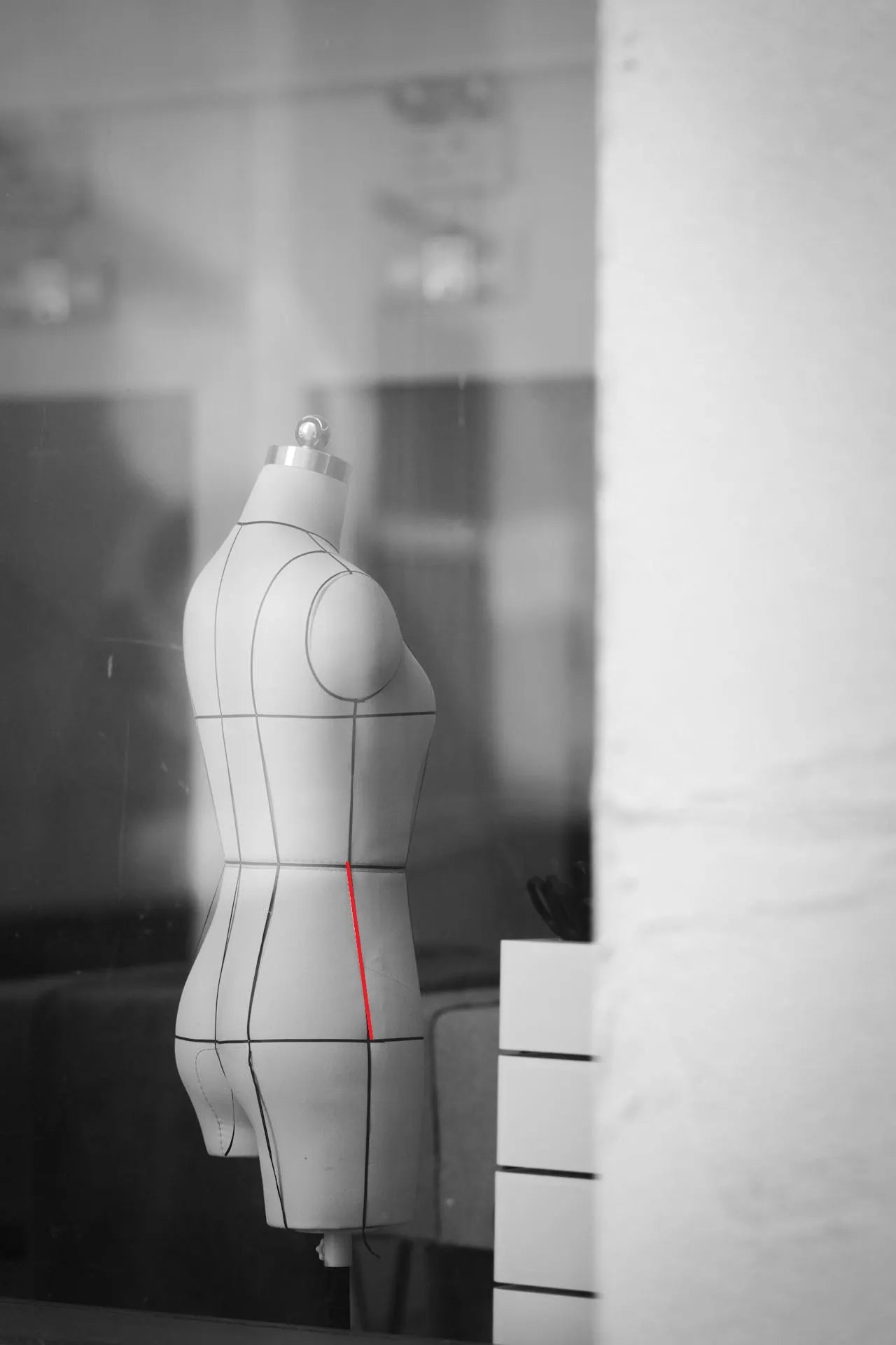 Maniquí indicando con una línea roja recta cómo medir la bajada de cadera desde la cintura hasta la cadera.