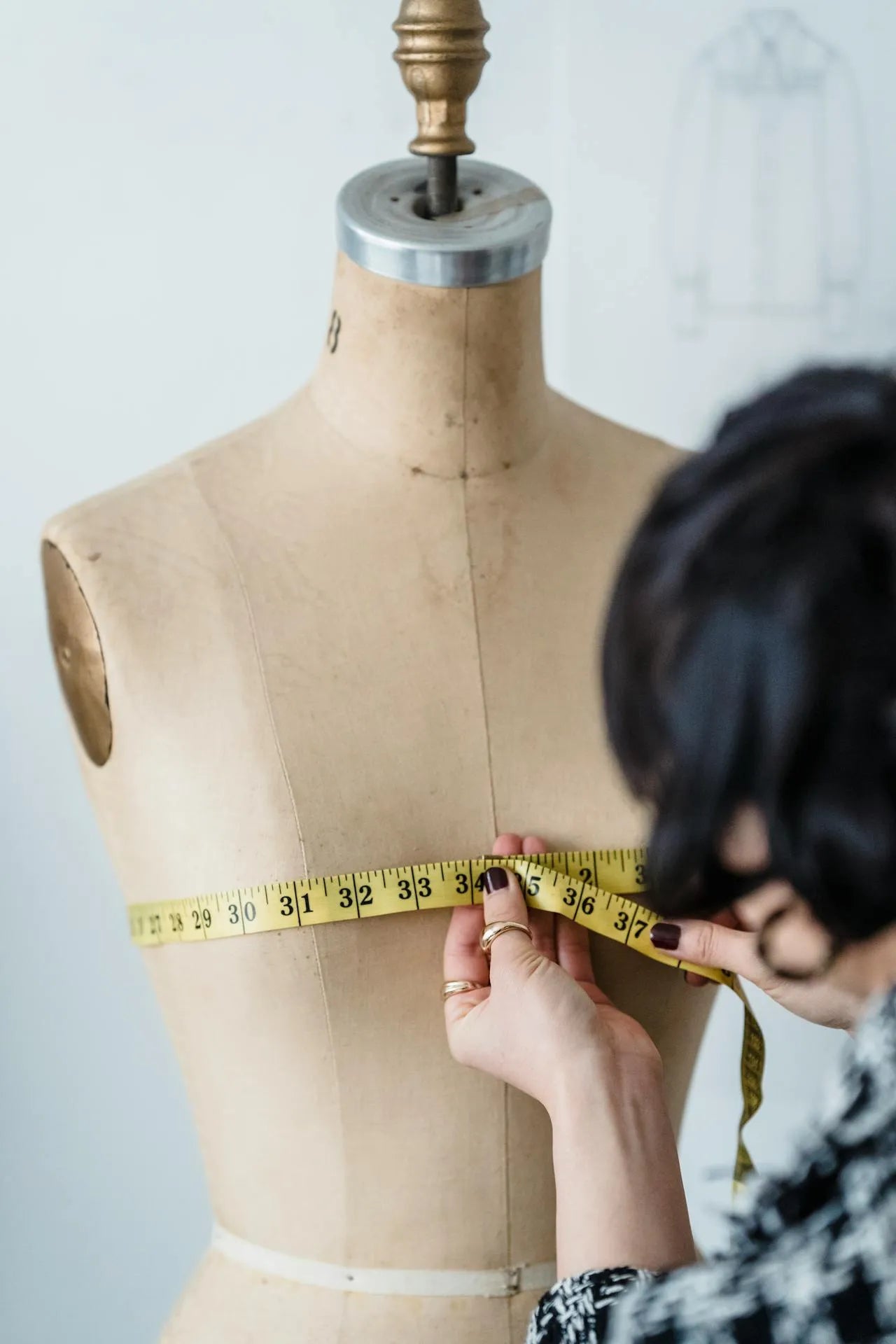 Maniquí indicando con un metro cómo medir el contorno de pecho rodeando su parte más sobresaliente.
