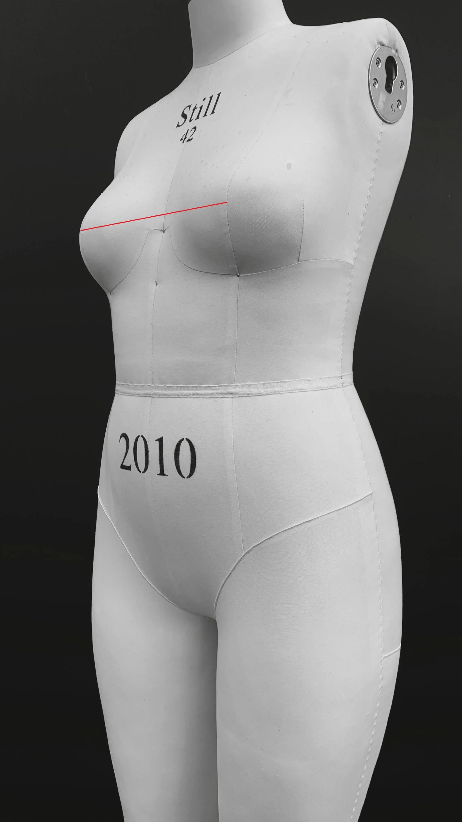 Maniquí indicando con una línea roja recta cómo medir la separación de centro pecho desde una punta hasta otra.