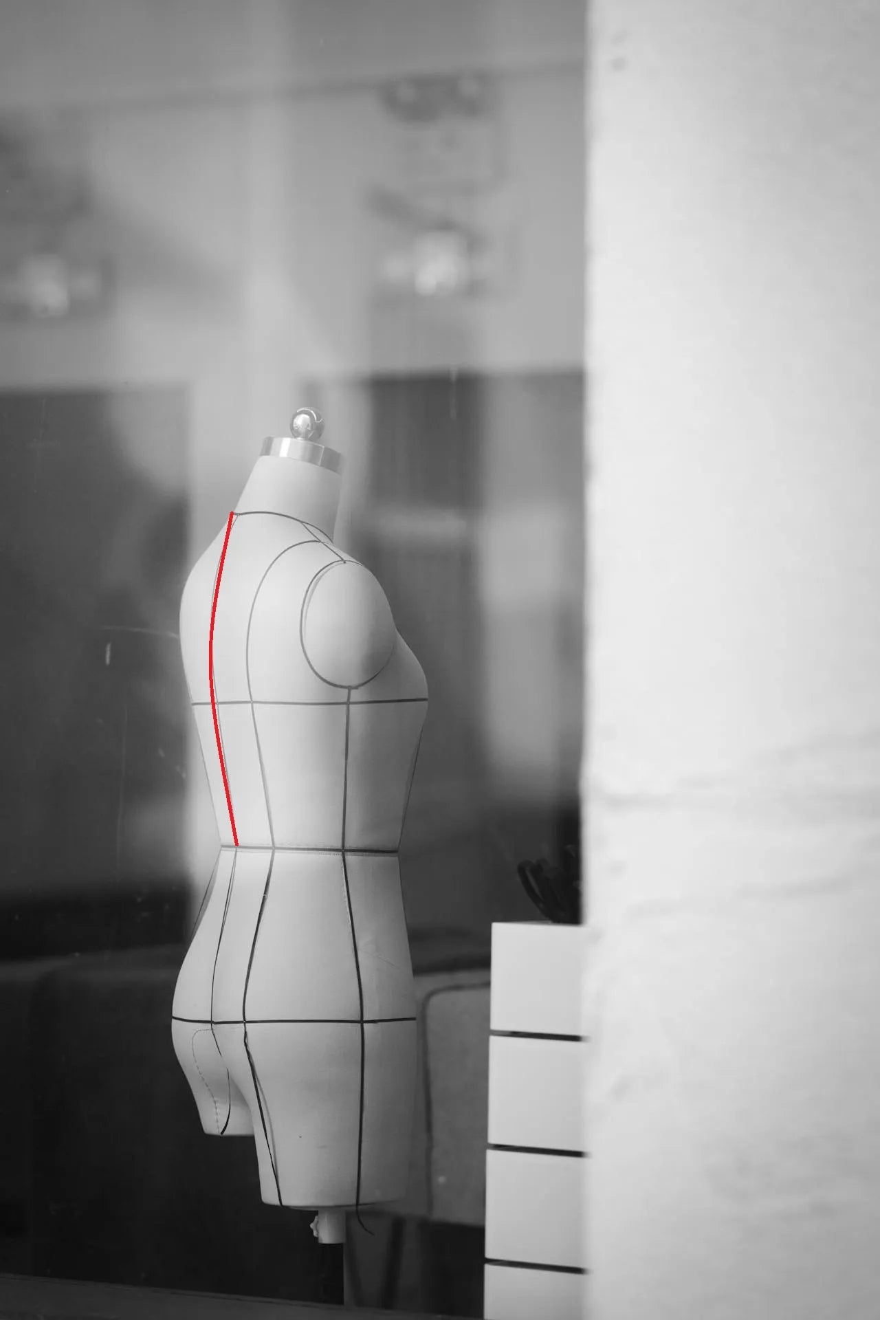 Maniquí indicando con una línea roja curva cómo medir el talle de espalda desde la base del cuello hasta la línea de cintura.