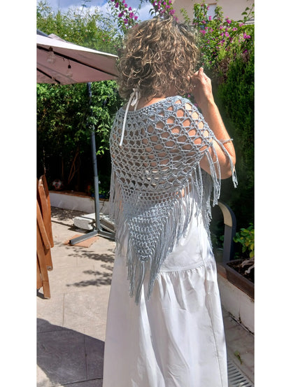Mujer luciendo la Capa Aurora de crochet en color gris sobre vestido blanco, vista trasera, patrón descargable EH NENA