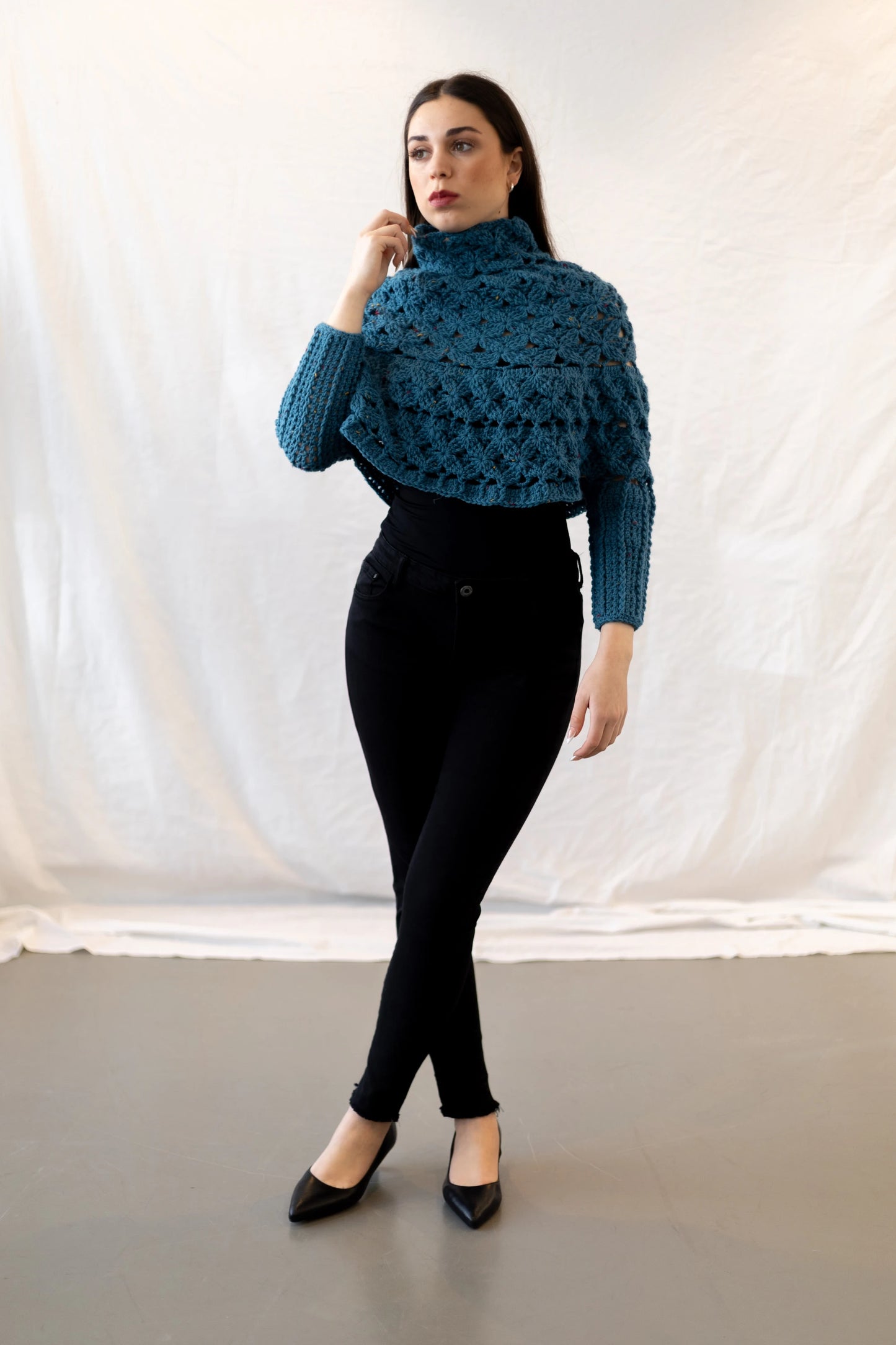 Vista frontal de cuerpo entero del Poncho Malala tejido a crochet con lana 100% de color azul y largo hasta cintura