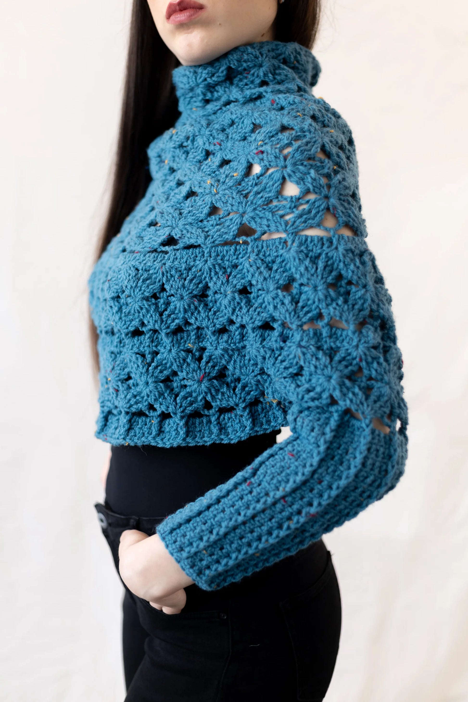 Vista lateral del Poncho Malala con mangas tejido a crochet con lana 100% de color azul y largo hasta cintura