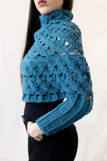 Vista lateral del Poncho Malala con mangas tejido a crochet con lana 100% de color azul y largo hasta cintura