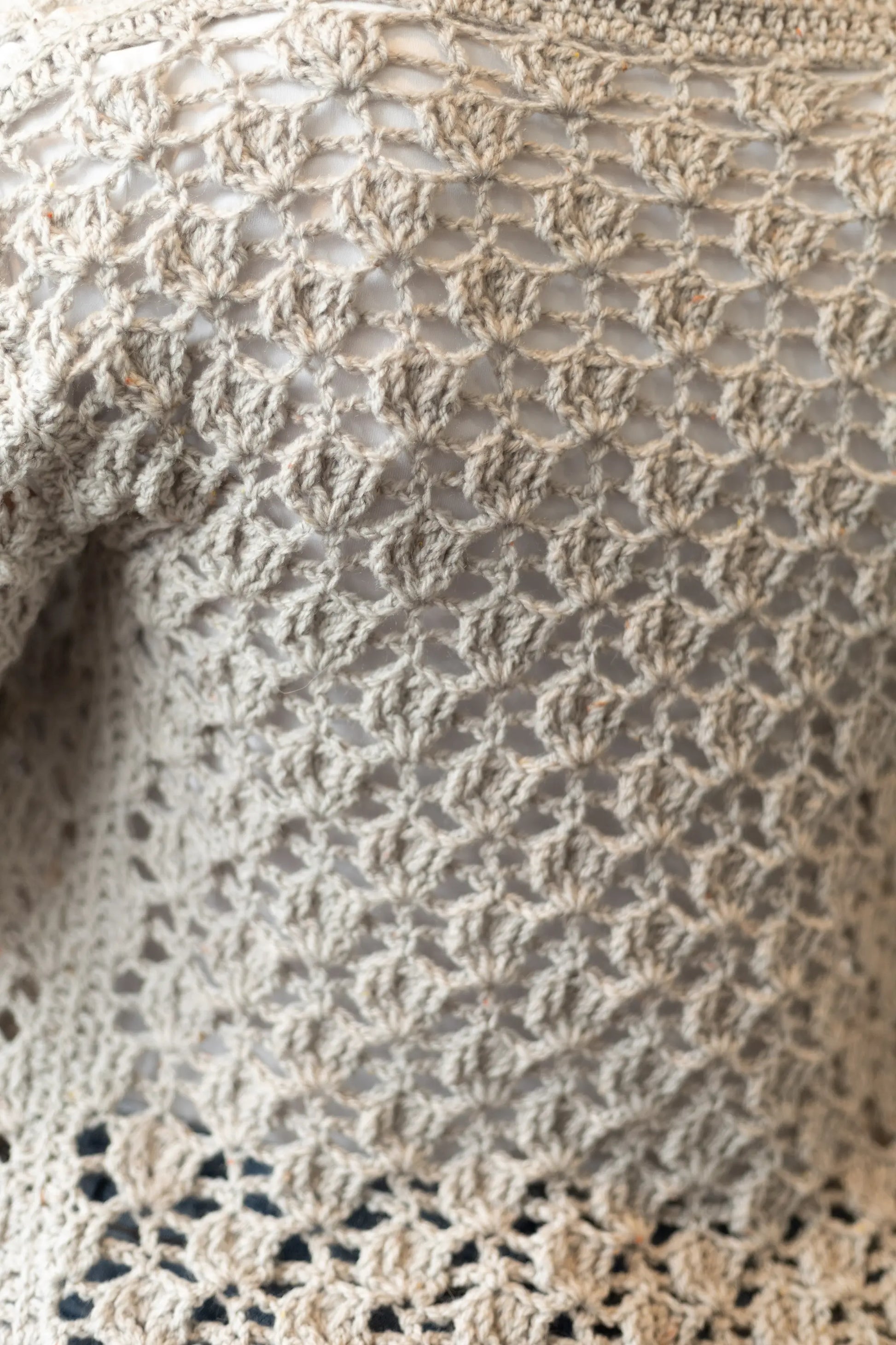 Vista detalle punto de la Rebeca Conchita en manga corta tejida a crochet con lana en color gris y blanco