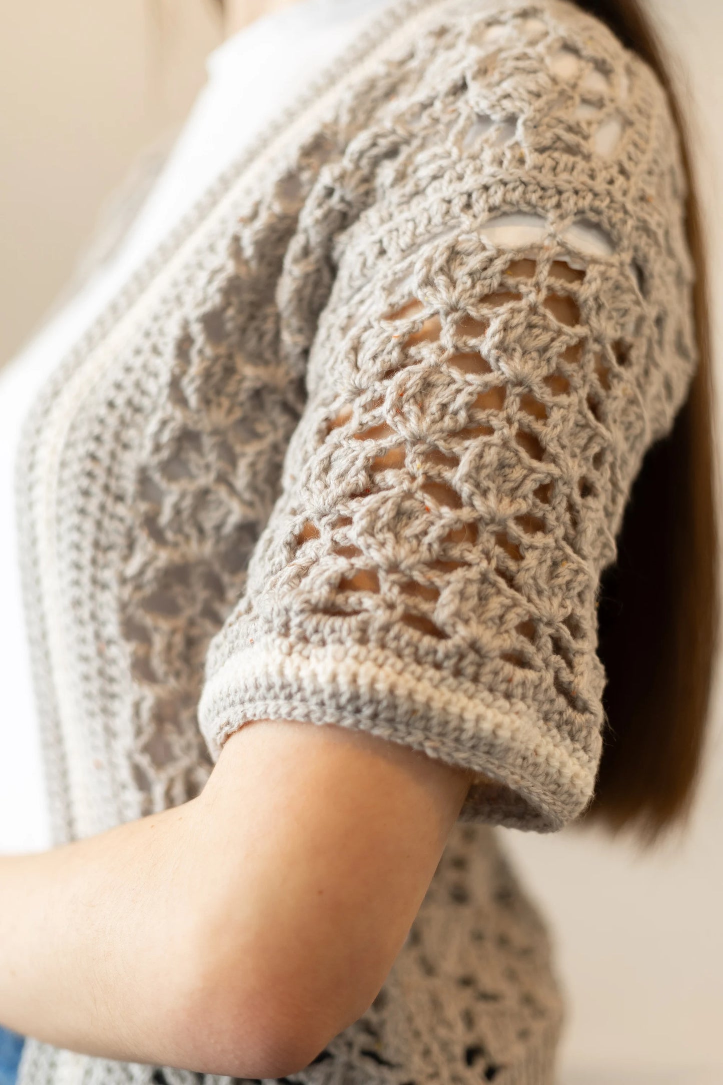 Vista detalle manga de la Rebeca Conchita en manga corta tejida a crochet con lana en color gris y blanco